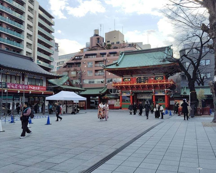 A traditional Japanese temple with a tiled courtyard, surrounded by modern buildings. 2