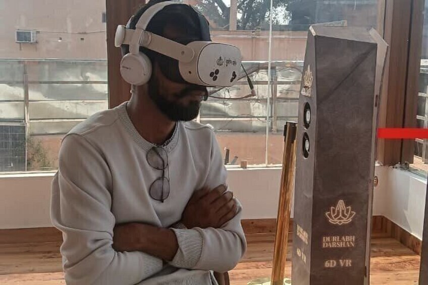 A person wearing a VR headset standing indoors with a window in the background. 2