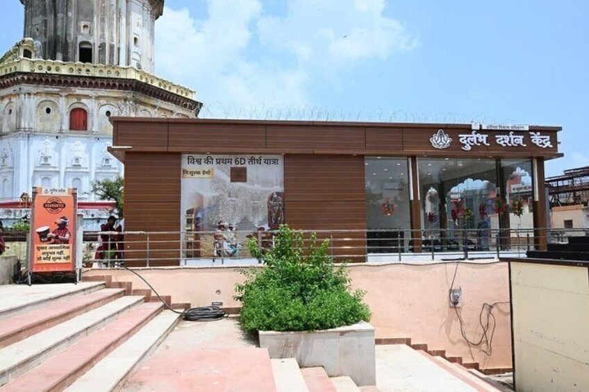 A building with a sign in a foreign language, a staircase, and a large white tower in the background. 5