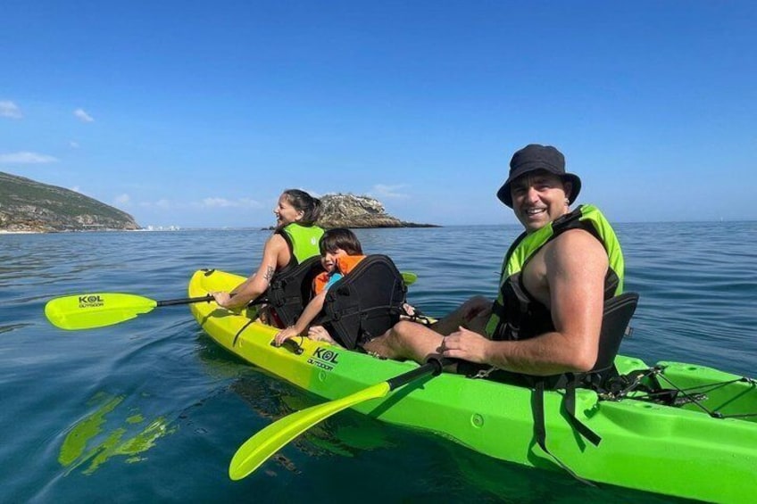 Three people kayaking on a calm sea with a clear sky. 4