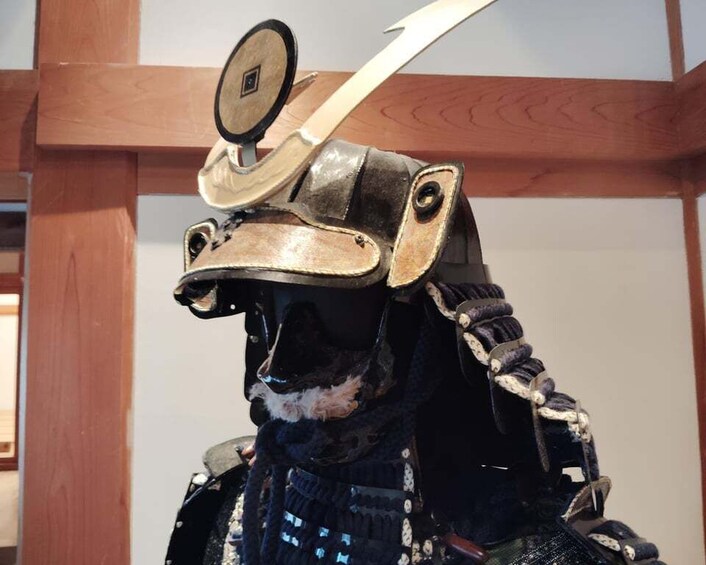 A person wearing a detailed samurai helmet with a decorative band and a sword. 4
