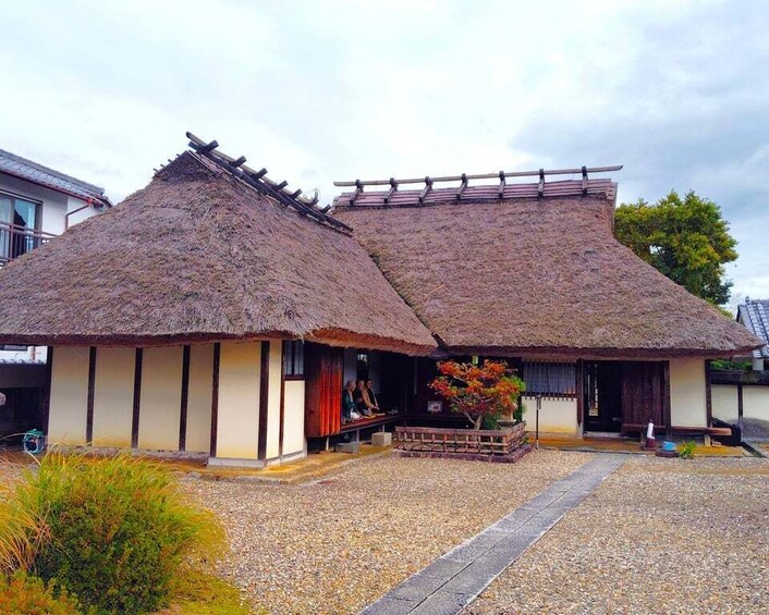 A traditional thatched-roof house with a gravel pathway and a small garden. 2