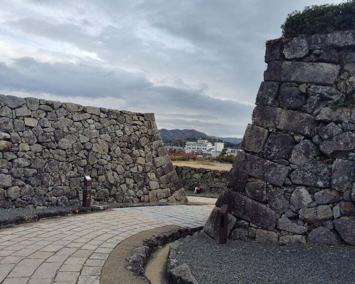 A stone wall and a paved path in a park. 5
