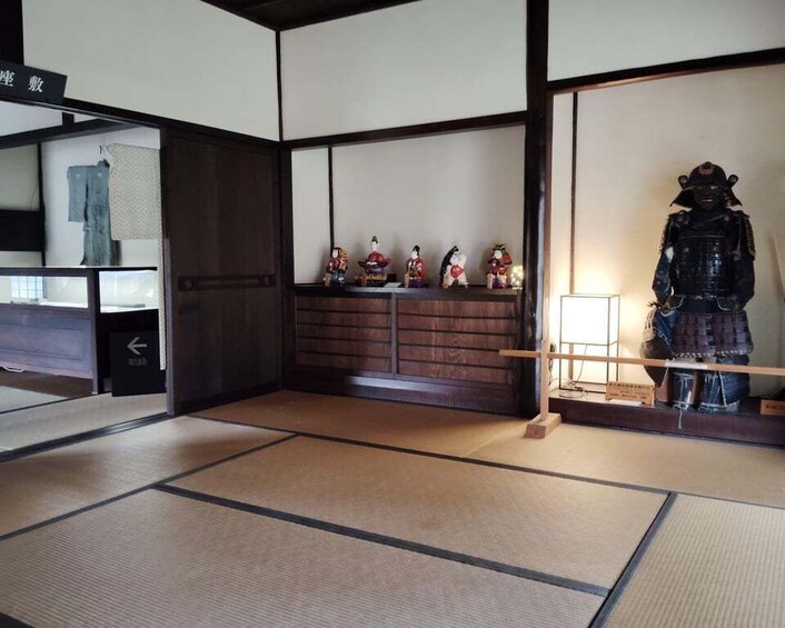 A traditional Japanese room with tatami flooring, a shoji screen, and a statue. 3