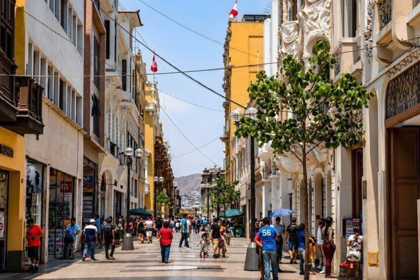 A bustling street with pedestrians, shops, and ornate buildings. 5