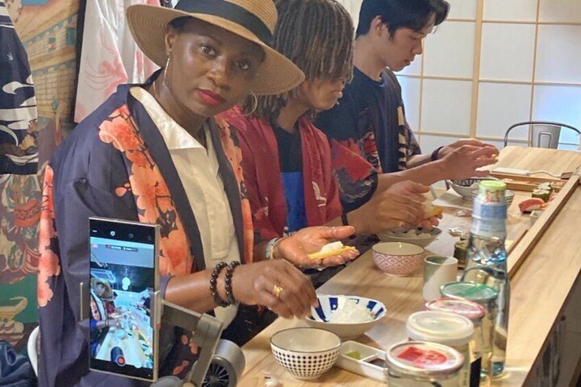A person preparing food with chopsticks, a bowl, and a smartphone. 3