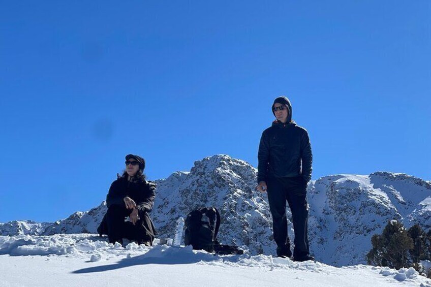 Two people on a snowy mountain with clear skies. 1