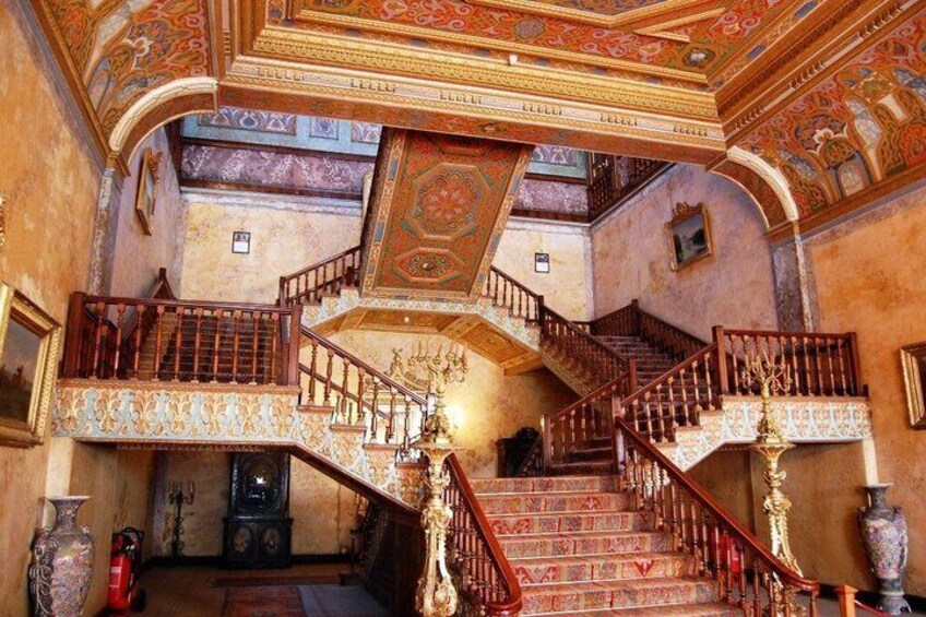 A grand staircase with ornate railings and a decorative ceiling. 3