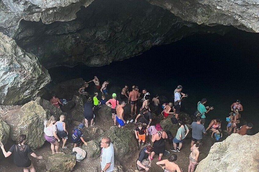 A group of people gathered at the entrance of a cave. 2