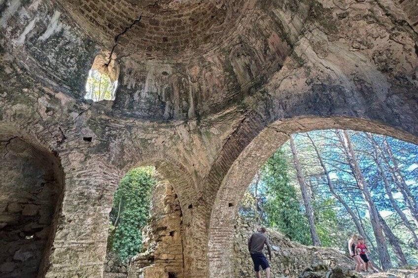 An ancient stone structure with arched openings and a hanging light fixture. 4