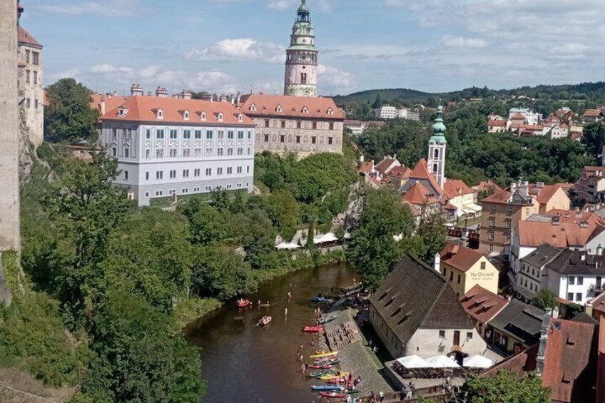 A river with boats, a prominent tower, and a historic building with a red roof. 1