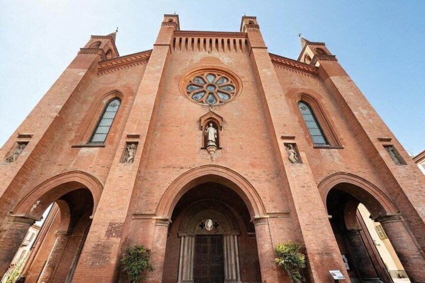 A large brick church with a prominent rose window and two large arched doorways. 3
