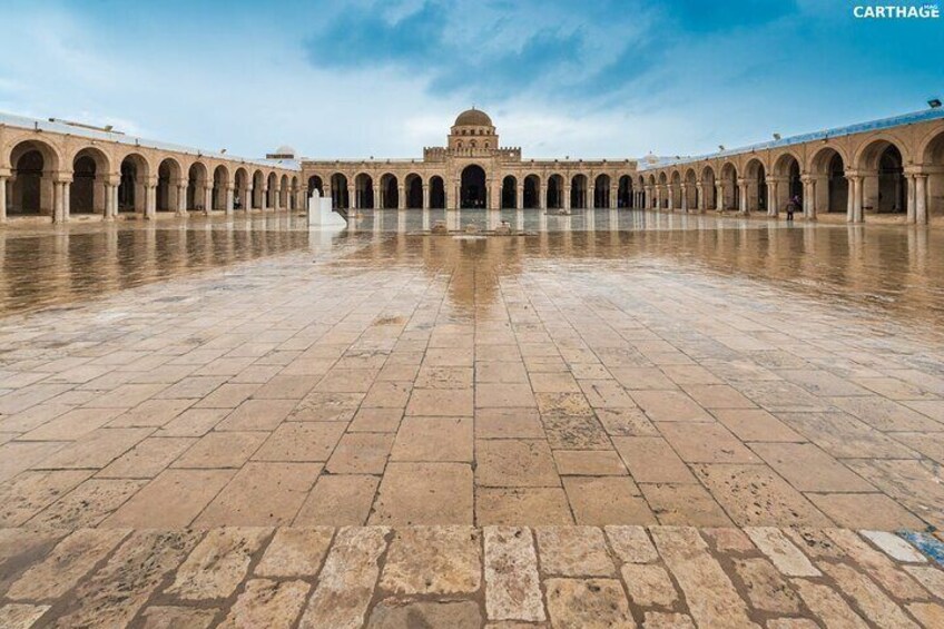A courtyard with a central dome, surrounded by arches, and a tiled floor. 2