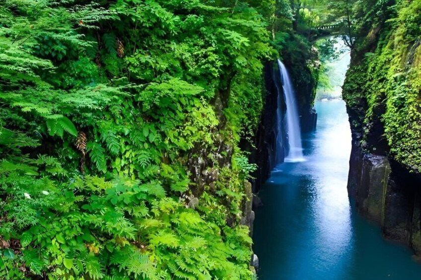 A waterfall in a lush green canyon. 4