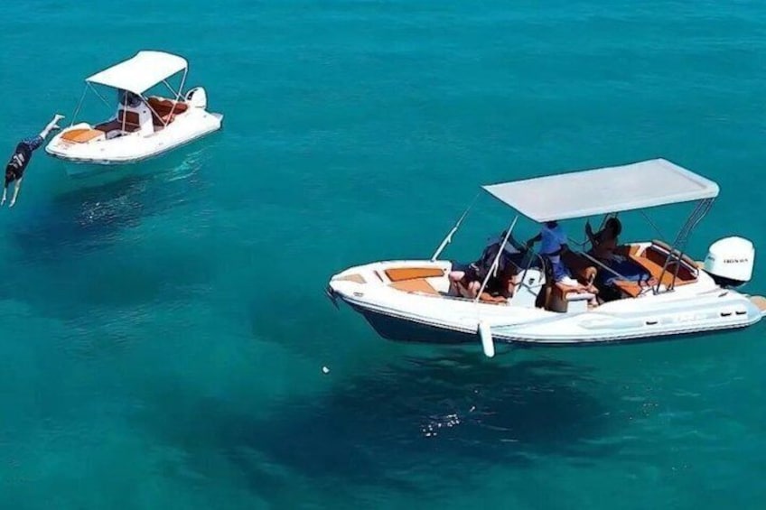 Two small motorboats with canopies on calm turquoise water. 5