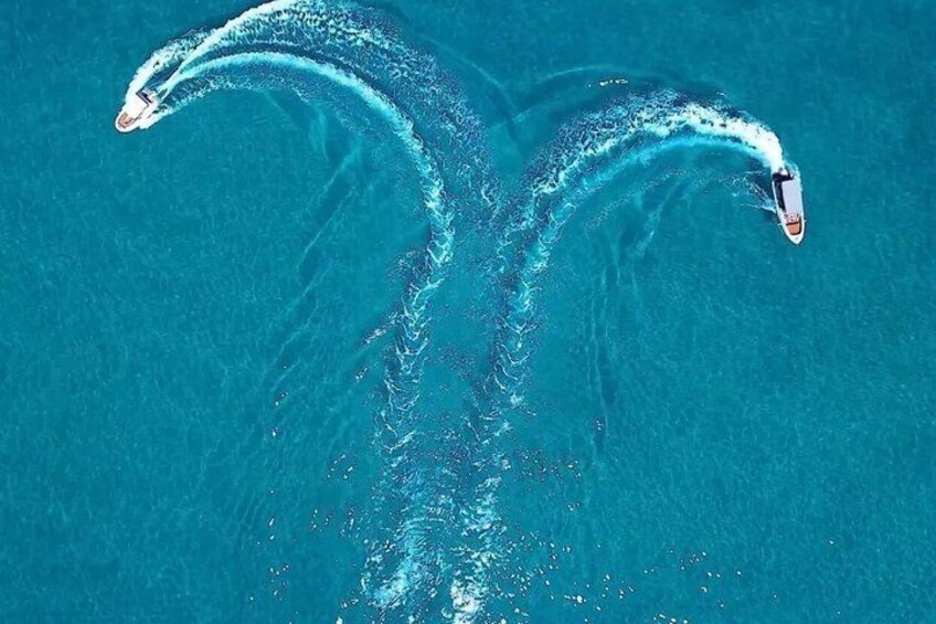 A boat creating a wake in turquoise water. 3