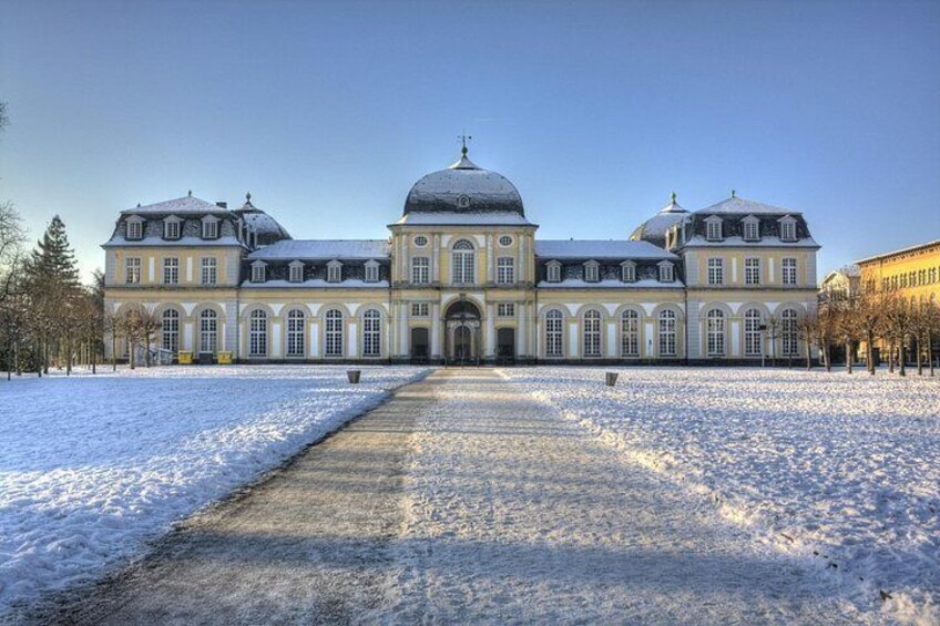 A large, historic building with a central dome and symmetrical wings, surrounded by a snow-covered courtyard. 2
