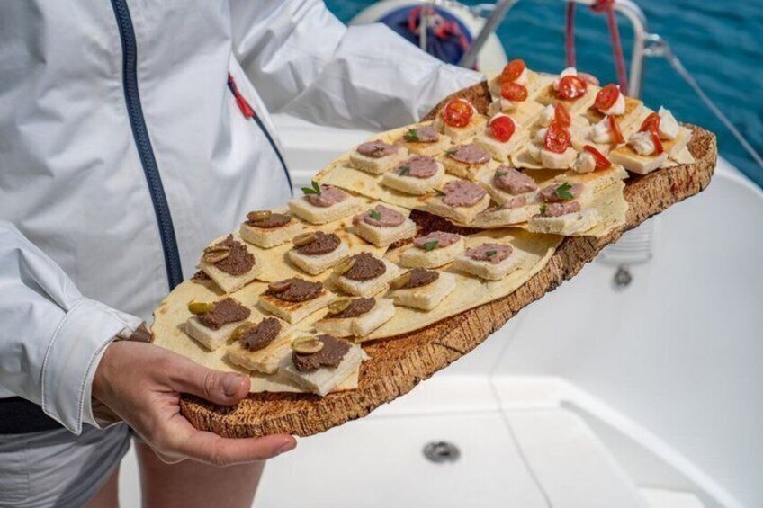 A person holding a large wooden board with various food items. 2