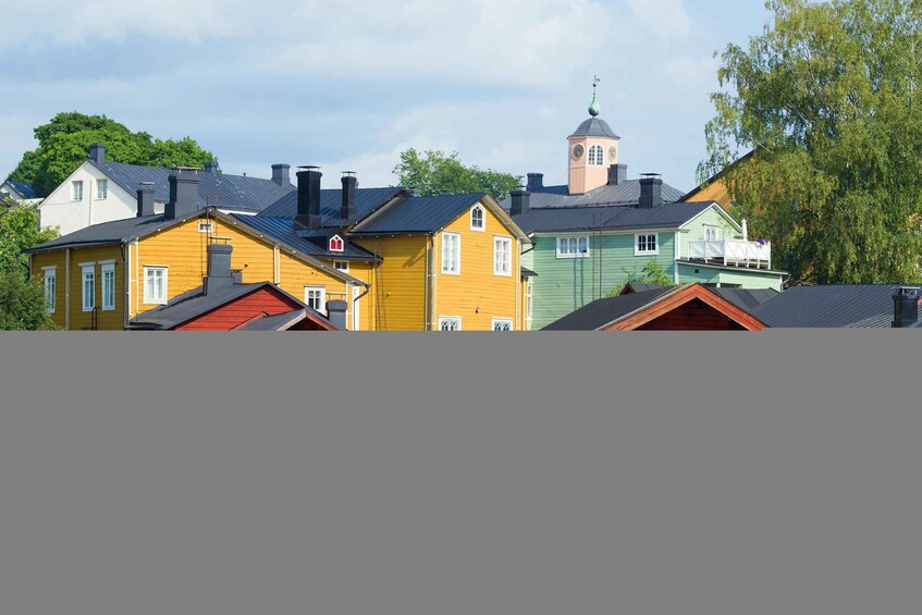 A row of colorful houses with a church tower in the background. 3