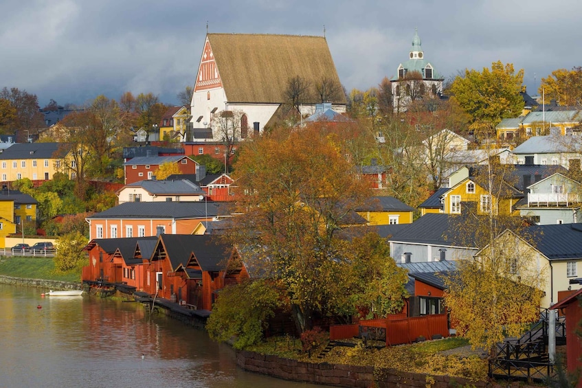 A riverside town with colorful houses, a church, and a tower. 1