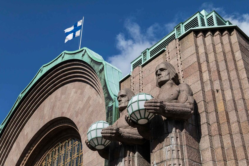 A building with a flag, a statue of a figure holding globes, and a large arched window. 4