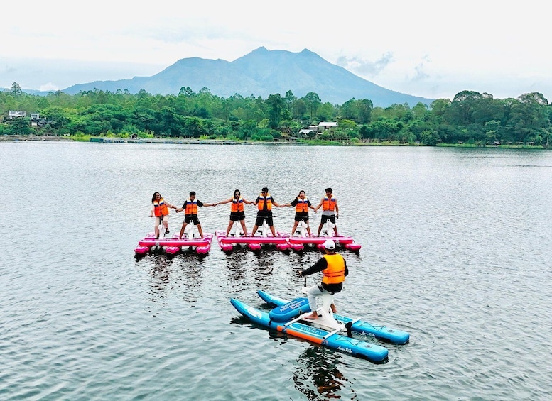 People on paddleboards in a calm lake with mountains in the background. 3
