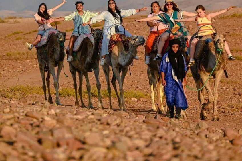 A group of people riding camels in a desert landscape. 3