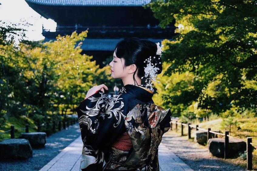 A person in traditional attire walking along a pathway with a historical building in the background. 3