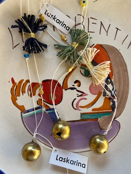 A decorative piece with a tag labeled 'Laskarina,' featuring a colorful illustration and hanging ornaments. 3