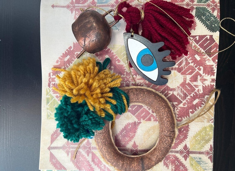 A patterned fabric with a copper pot, a yarn ball, a decorative eye, and a woven basket. 1