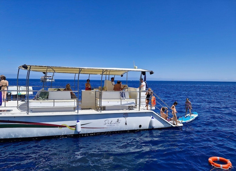 A boat with people on board and a lifebuoy in the water. 3