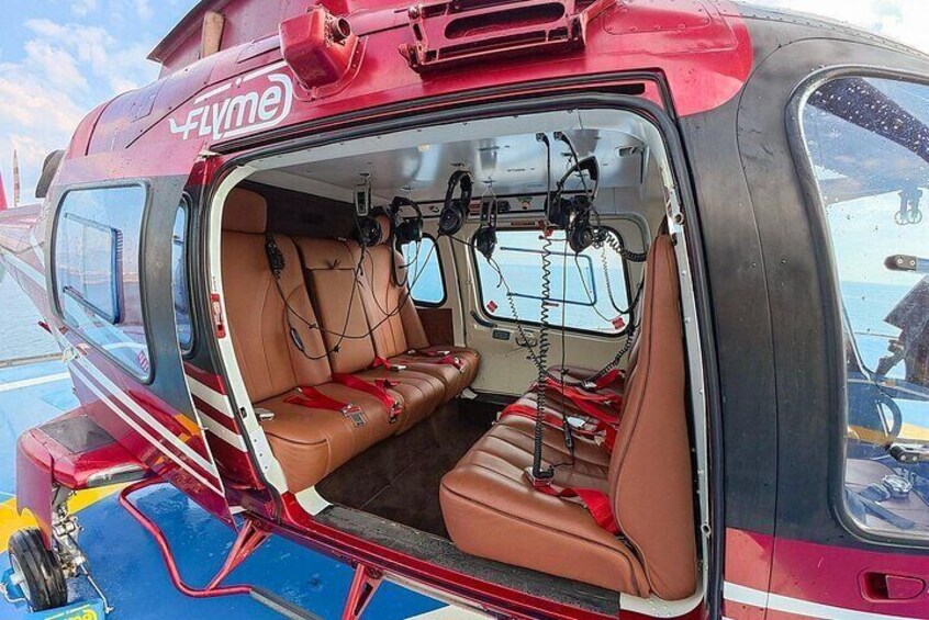 A red and black helicopter with brown leather seats and a 'Flyme' logo. 4