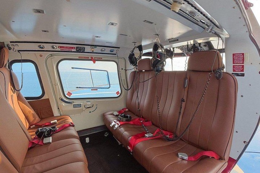 A vehicle interior with leather seats, headrests, and safety belts. 5