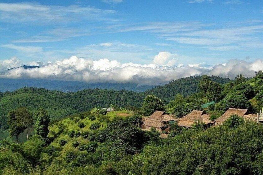A mountainous landscape with thatched-roof houses and lush greenery. 4