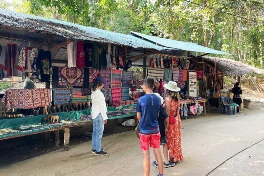 A market stall with colorful textiles and a thatched roof. 2
