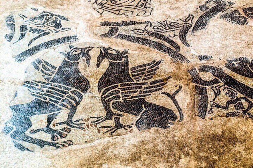 A mosaic with stylized animal figures, possibly mythological, on a textured surface. 3