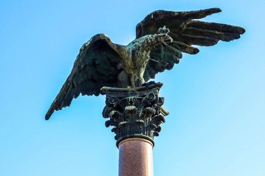 A bronze eagle statue atop a column with ornate details. 2