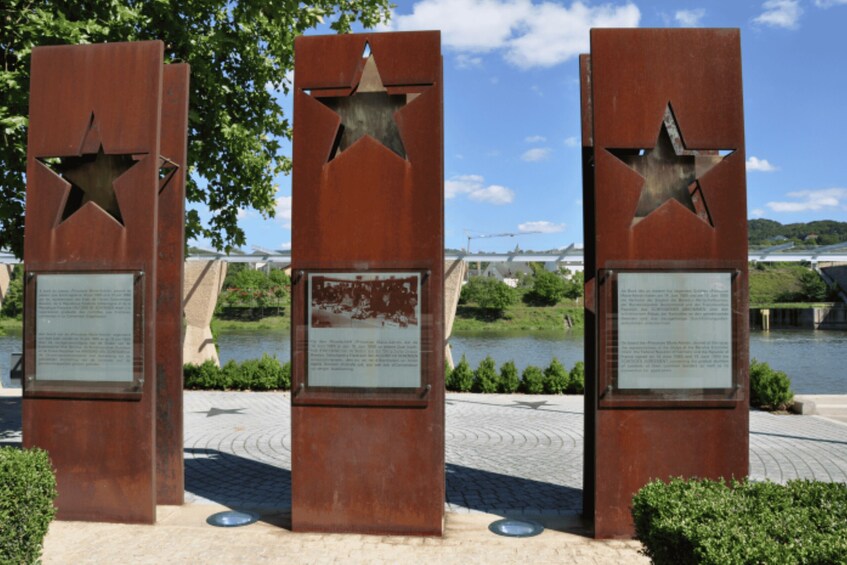 Three rusted metal structures with star cutouts and informational plaques. 4