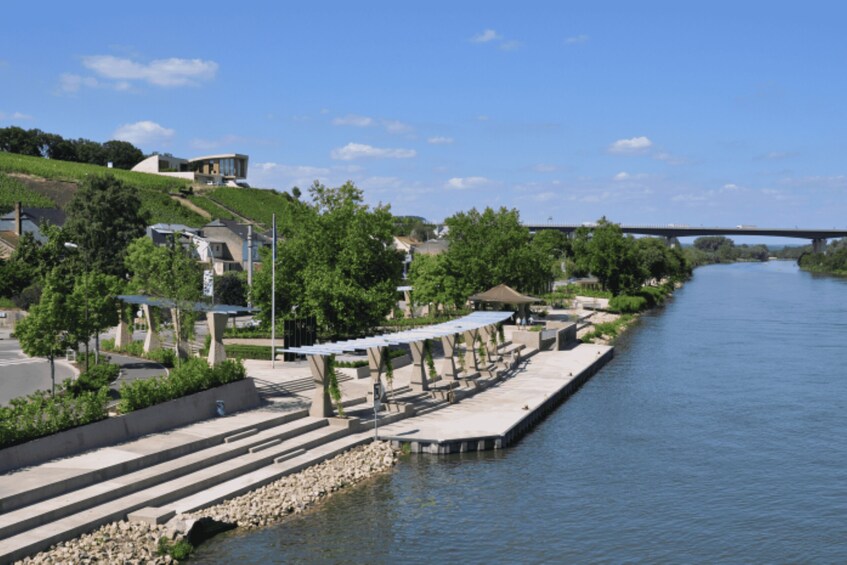 A river with a bridge, steps leading to a dock, and buildings along the riverbank. 2