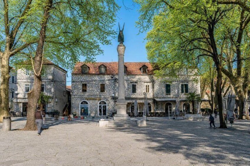 A historic building with a central monument, surrounded by trees and open space. 4
