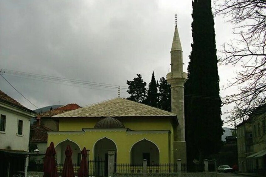 A mosque with a minaret, a dome, and arched entrances. 5