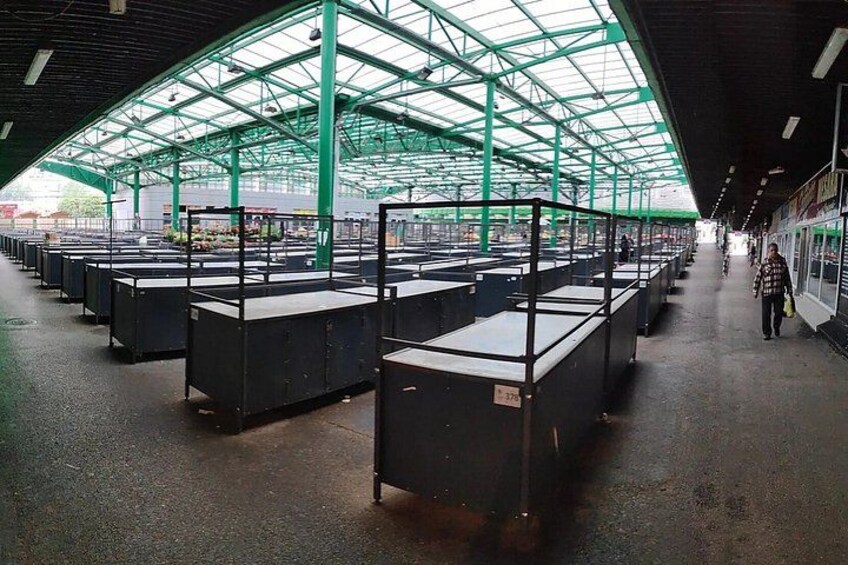 A covered indoor market with rows of black crates. 2