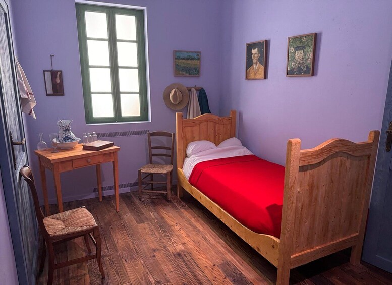 A room with a wooden bed, a desk, a chair, a window, and two wall-mounted pictures. 1