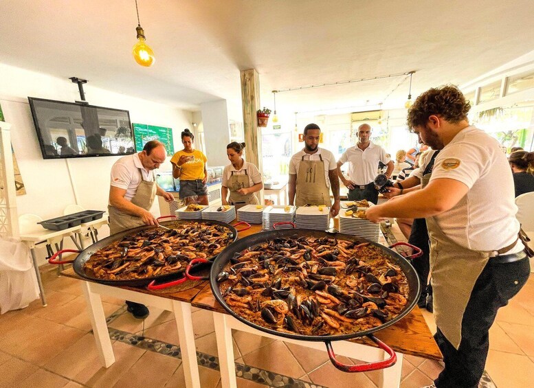 A group of people preparing seafood dishes in a kitchen. 5