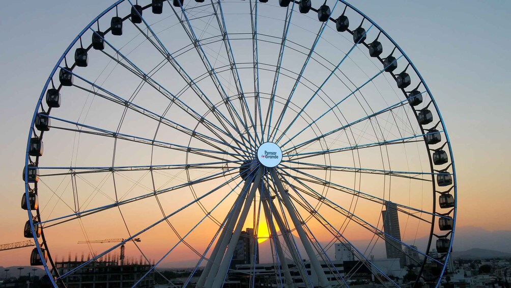 A large Ferris wheel with a sunset in the background. 4