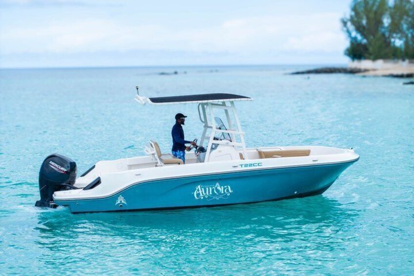 A boat named 'Aurora' on calm waters with a person steering it. 4