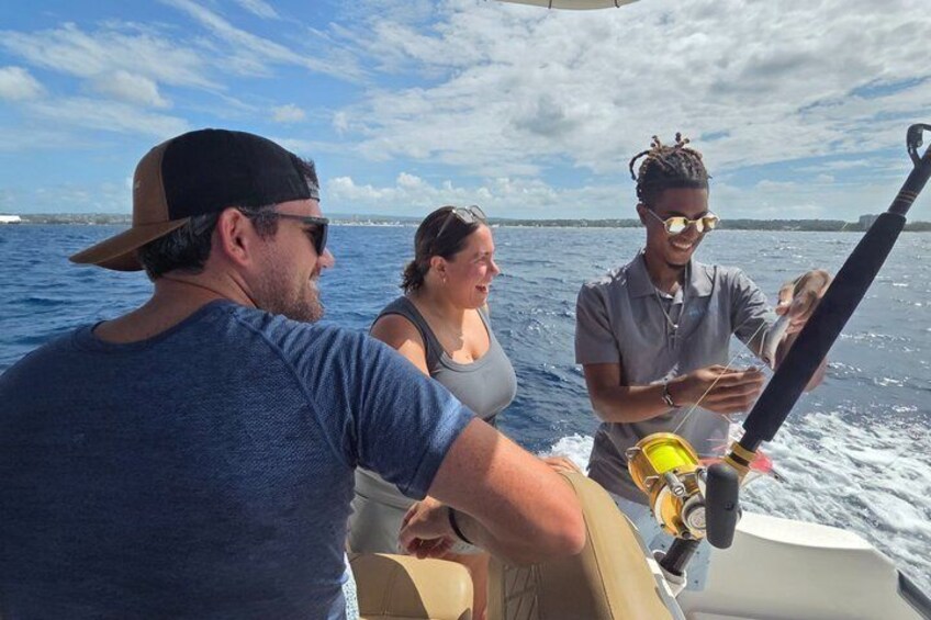 A boat with three people, one holding a fishing rod. 1