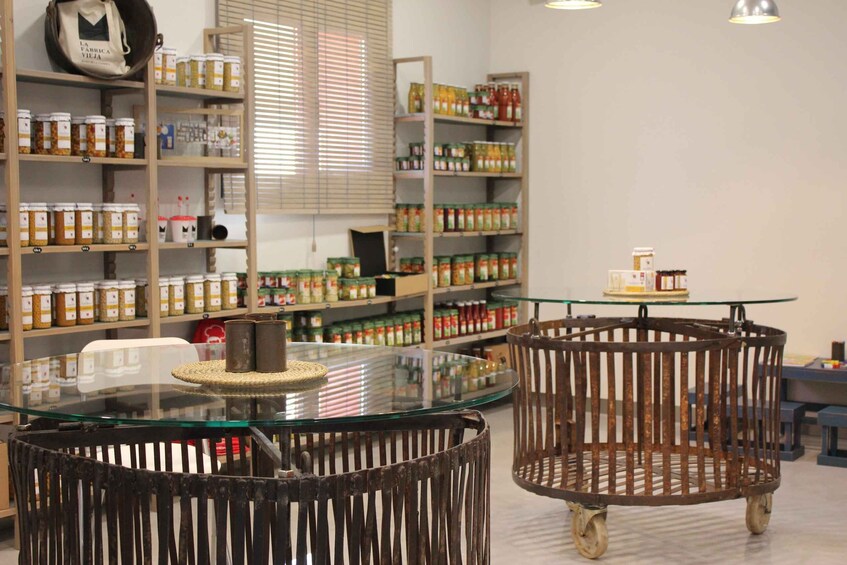 A store interior with shelves stocked with jars and a glass table with a woven basket. 3