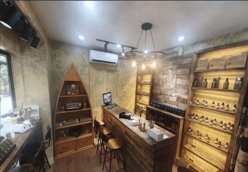 A bar with wooden shelves, stools, and a hanging light fixture. 2