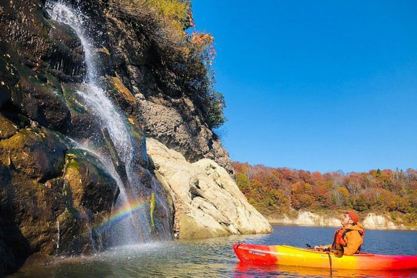 A waterfall, a kayaker, and autumn foliage. 2